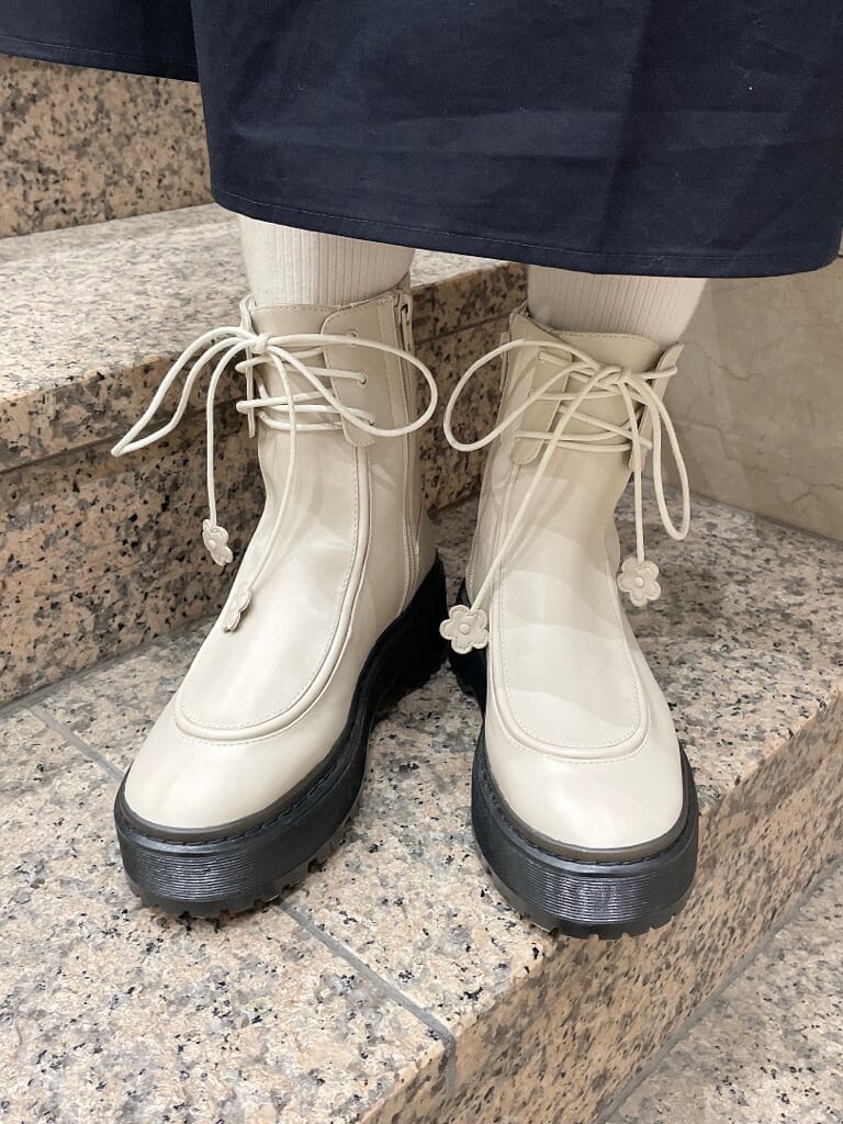 ホワイト系のブーツ、ホワイト系のブルゾン、ブラック系のワンピースを着用したレディースの冬コーディネートの7枚目の写真