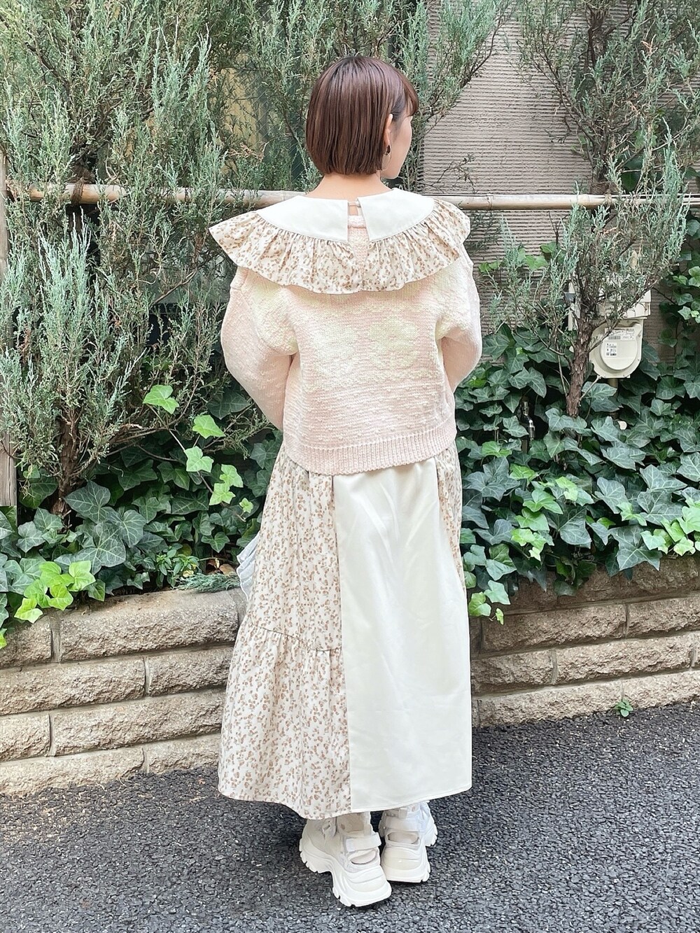 ベージュ系のワンピース、ピンク系のカーディガン/ボレロ、ホワイト系のトートバッグを着用したレディースの冬コーディネートの3枚目の写真