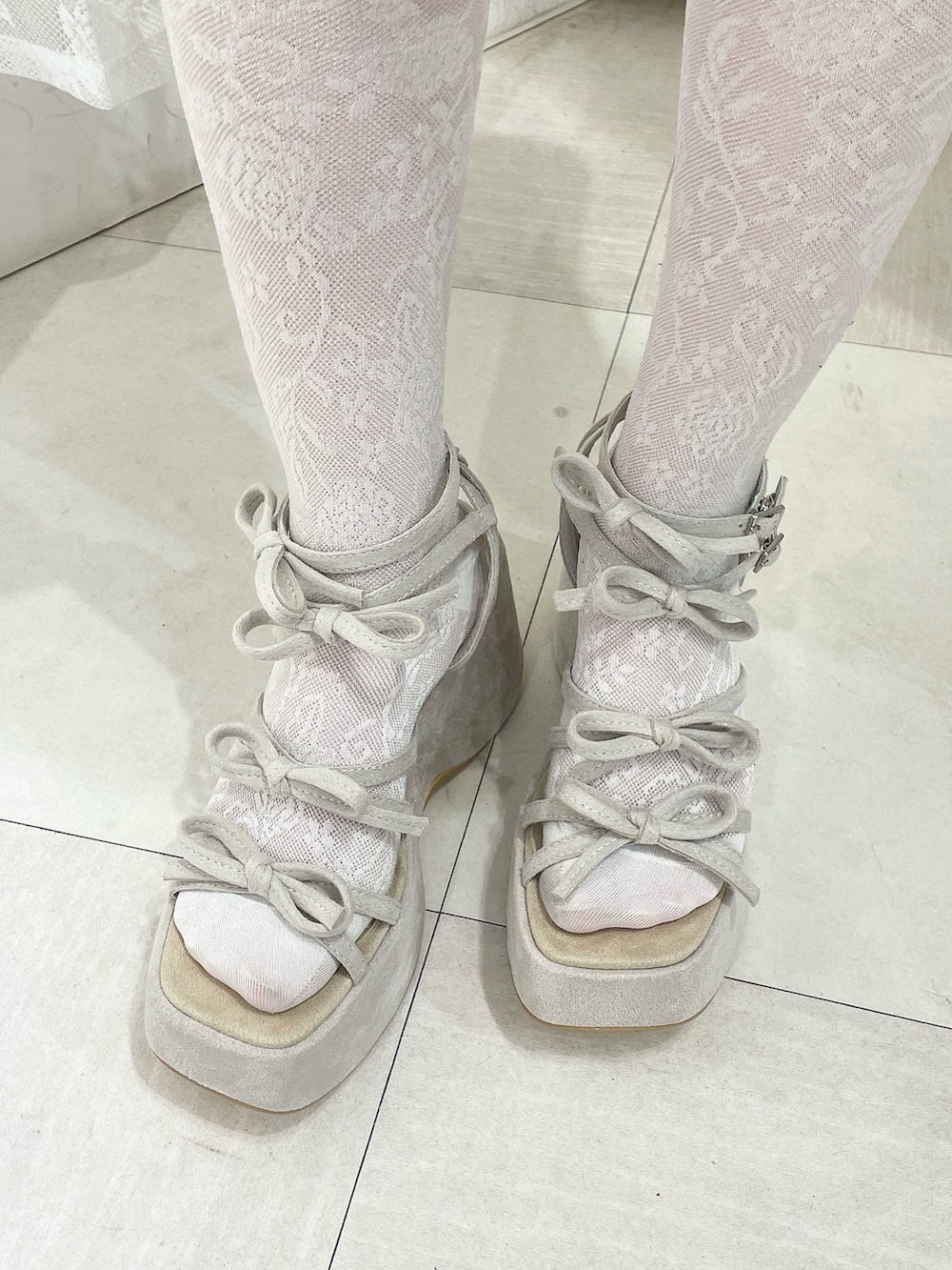 ピンク系のワンピース、ベージュ系のサンダルを着用したレディースの冬コーディネートの7枚目の写真