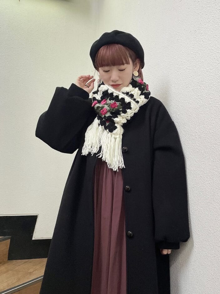 ブラック系のブーツ、ブラック系のステンカラーコート、レッド系のワンピースを着用したレディースの秋コーディネートの3枚目の写真