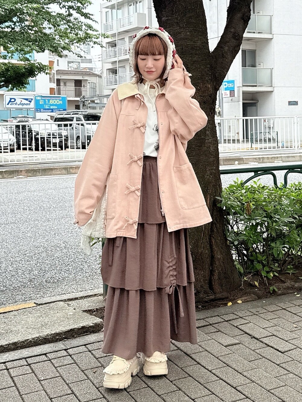 ピンク系のブルゾン、ホワイト系のTシャツ/カットソー、ブラウン系のスカートを着用したレディースの夏コーディネートの2枚目の写真