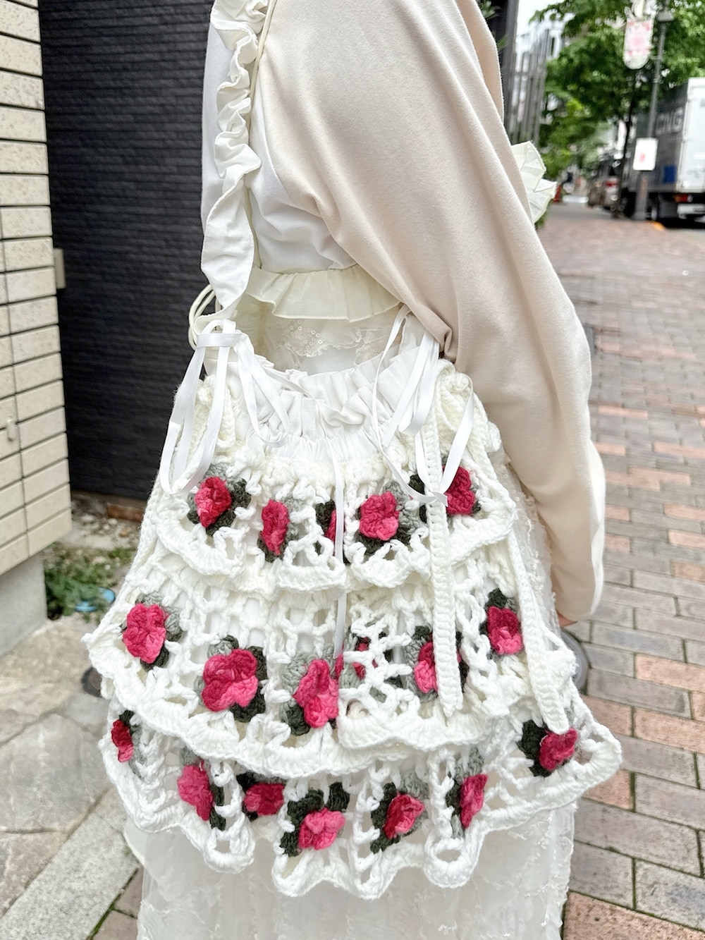 ベージュ系のTシャツ/カットソー、ホワイト系のワンピース、ホワイト系のスカートを着用したレディースの夏コーディネートの6枚目の写真