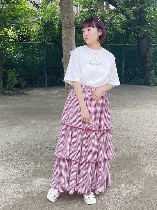 ホワイト系のサンダル、レッド系のスカート、ホワイト系のTシャツ/カットソーを着用したレディースの夏コーディネートの2枚目の写真