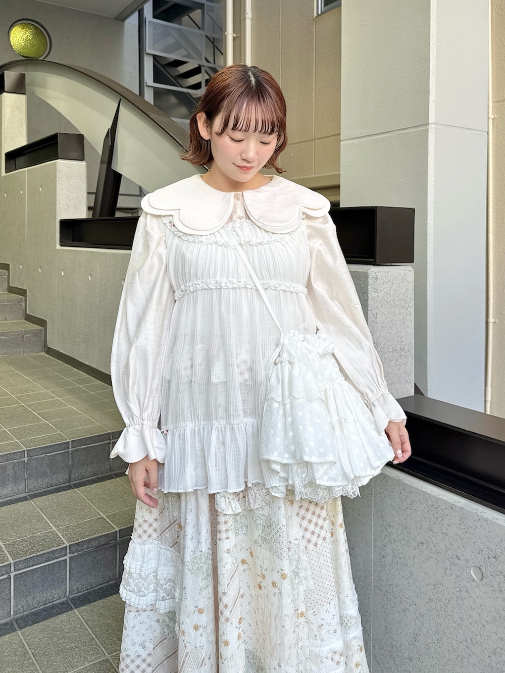 ピンク系のシャツ/ブラウス、ホワイト系のスカート、ホワイト系のチュニックを着用したレディースの春コーディネートの4枚目の写真