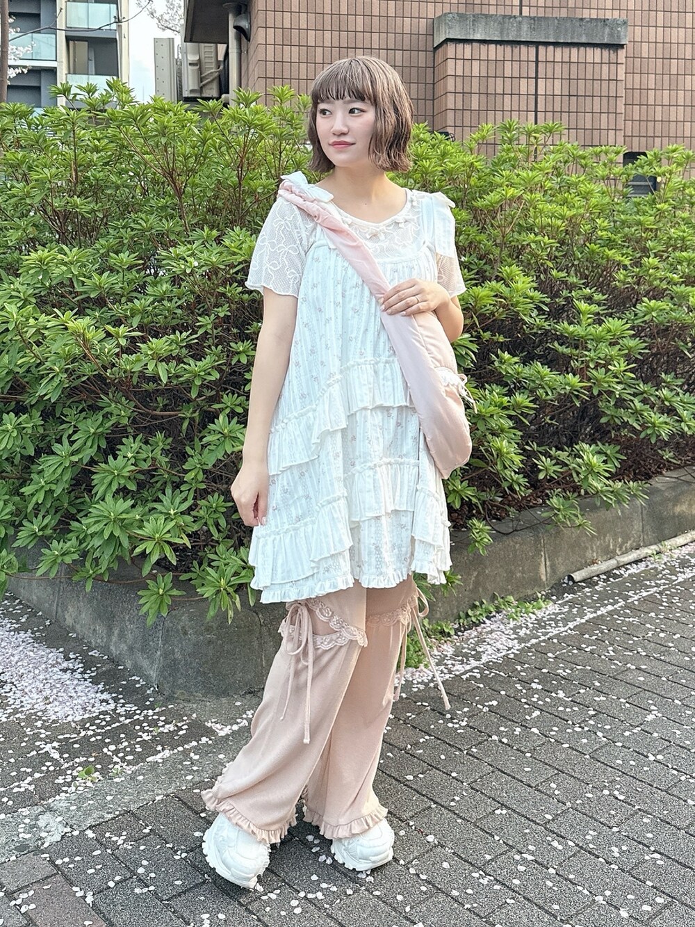 ピンク系のショルダーバッグ、ホワイト系のTシャツ/カットソー、ピンク系のワンピースを着用したレディースの春コーディネートの2枚目の写真