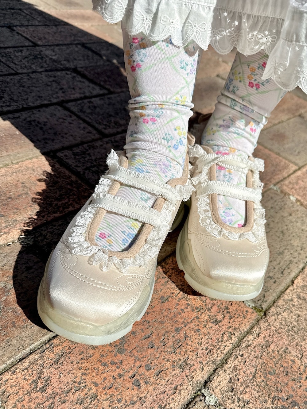 ピンク系のベスト、ピンク系のTシャツ/カットソー、ホワイト系のスカートを着用したレディースの春コーディネートの9枚目の写真