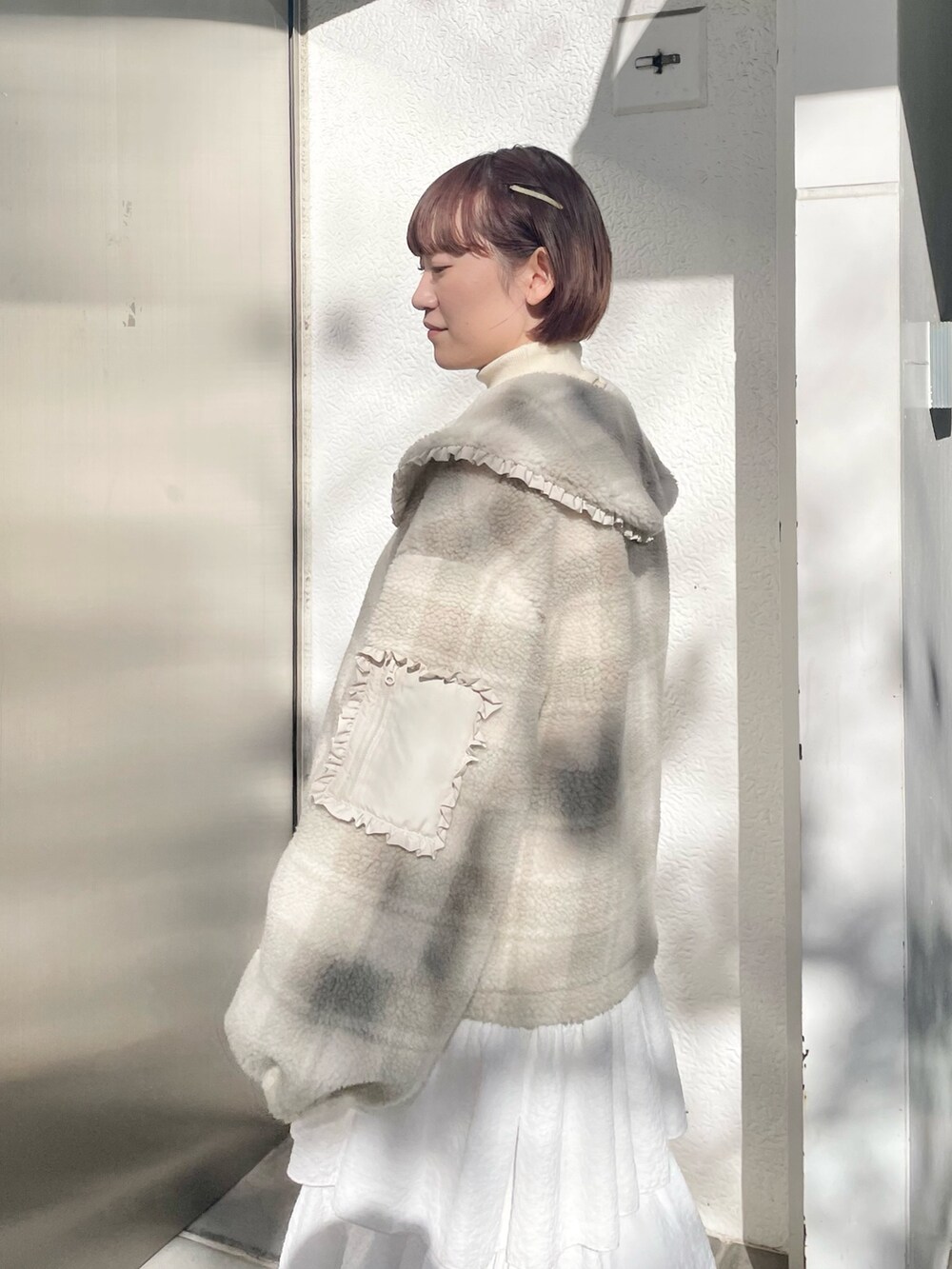 ホワイト系のスカート、ベージュ系のブルゾン、ホワイト系のニット/セーターを着用したレディースの冬コーディネートの7枚目の写真