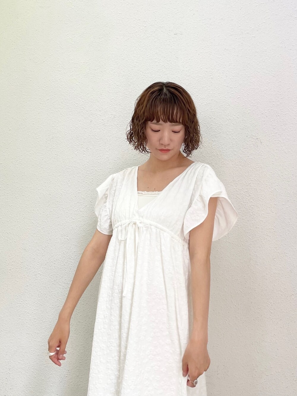 ホワイト系のキャミソール、ホワイト系のワンピース、ゴールド系のパンプスを着用したレディースの春コーディネートの5枚目の写真