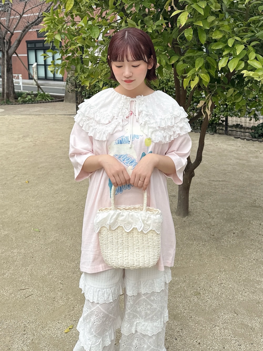 ピンク系のTシャツ/カットソー、ホワイト系のかごバッグ、ホワイト系のスニーカーを着用したレディースの春コーディネートの4枚目の写真