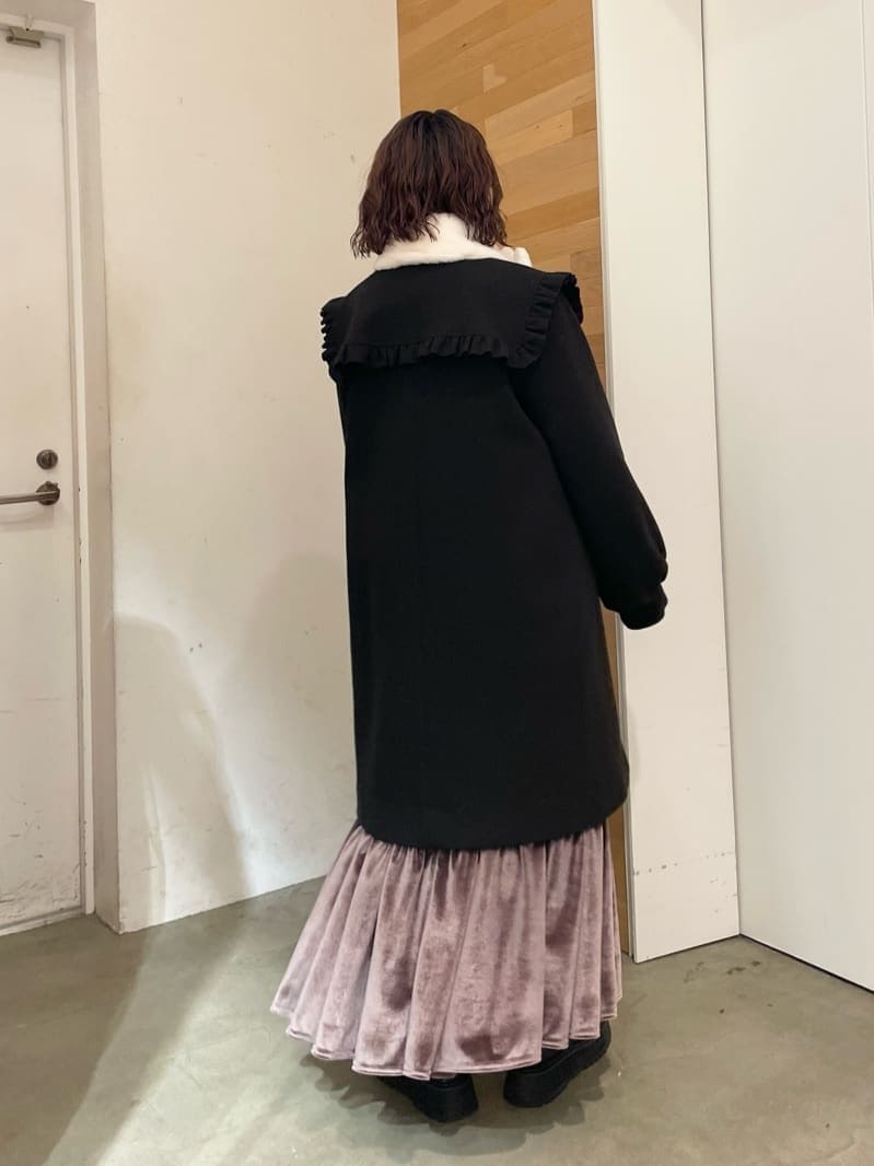 パープル系のスカート、ブラック系のローファー、ブラック系のステンカラーコートを着用したレディースの秋コーディネートの3枚目の写真