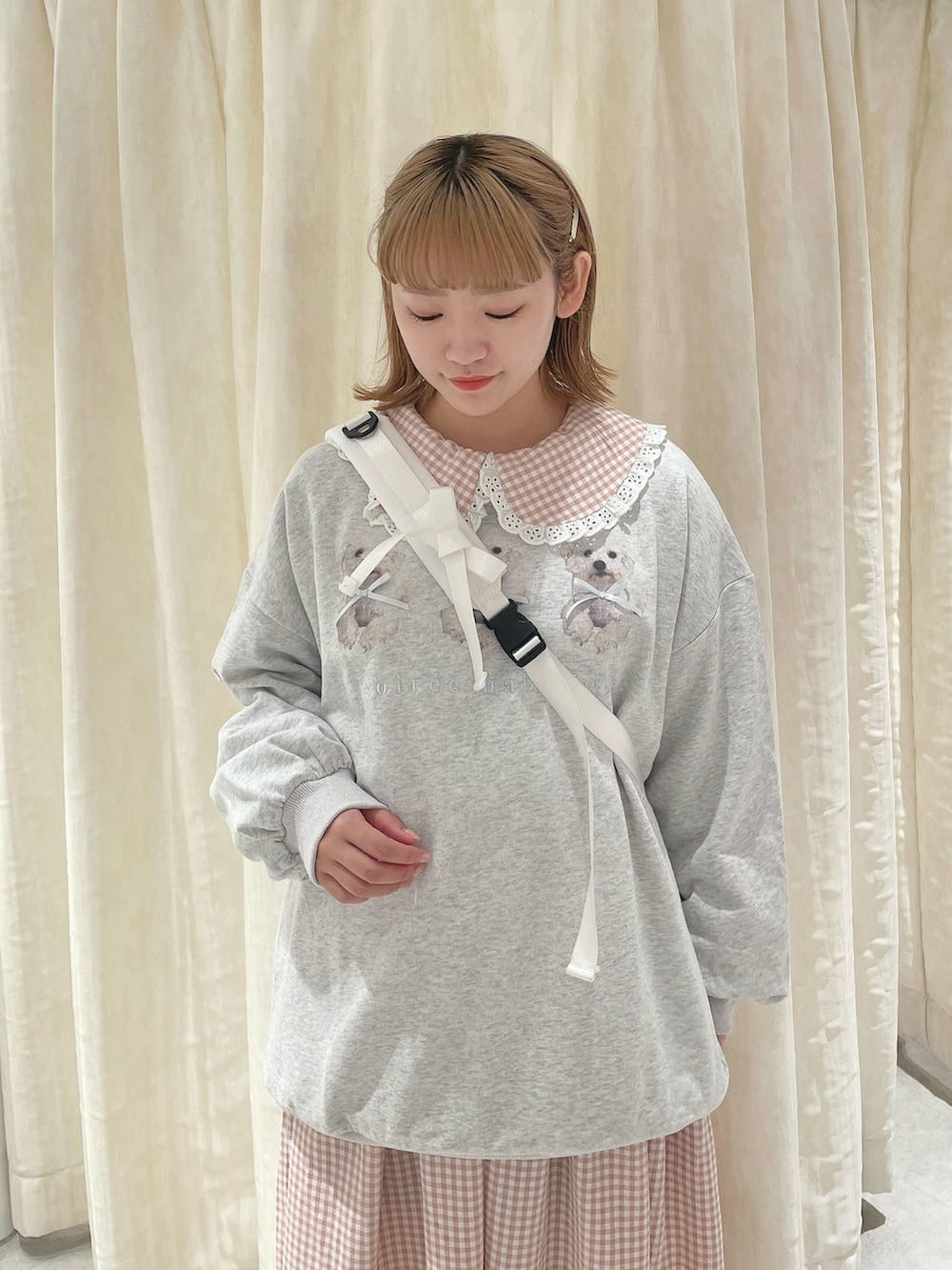 ホワイト系のショルダーバッグ、グレー系のスウェット、ピンク系のワンピースを着用したレディースの冬コーディネートの4枚目の写真