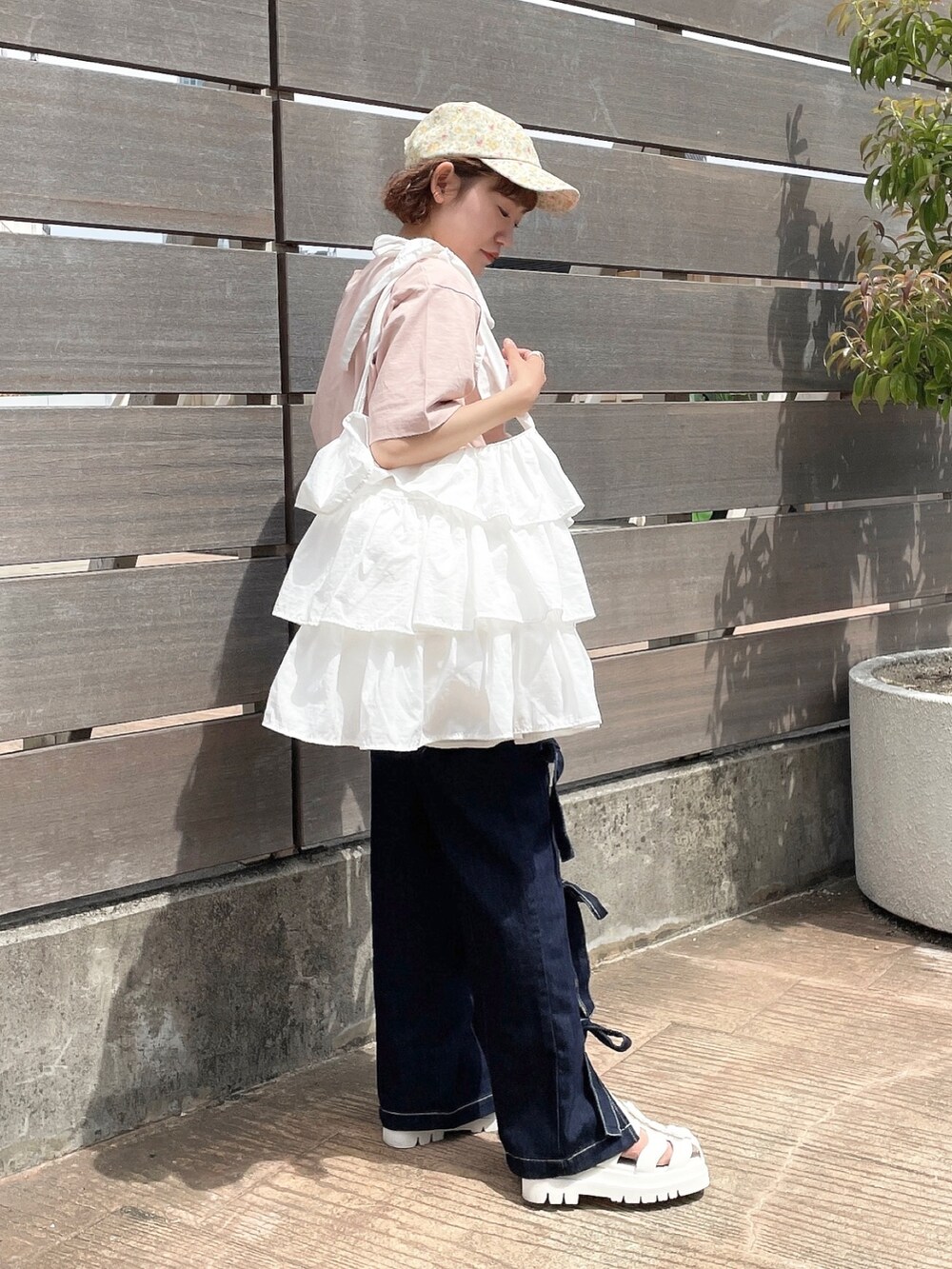 ピンク系のTシャツ/カットソー、ホワイト系のトートバッグ、ブルー系のデニムパンツを着用したレディースの春コーディネートの4枚目の写真