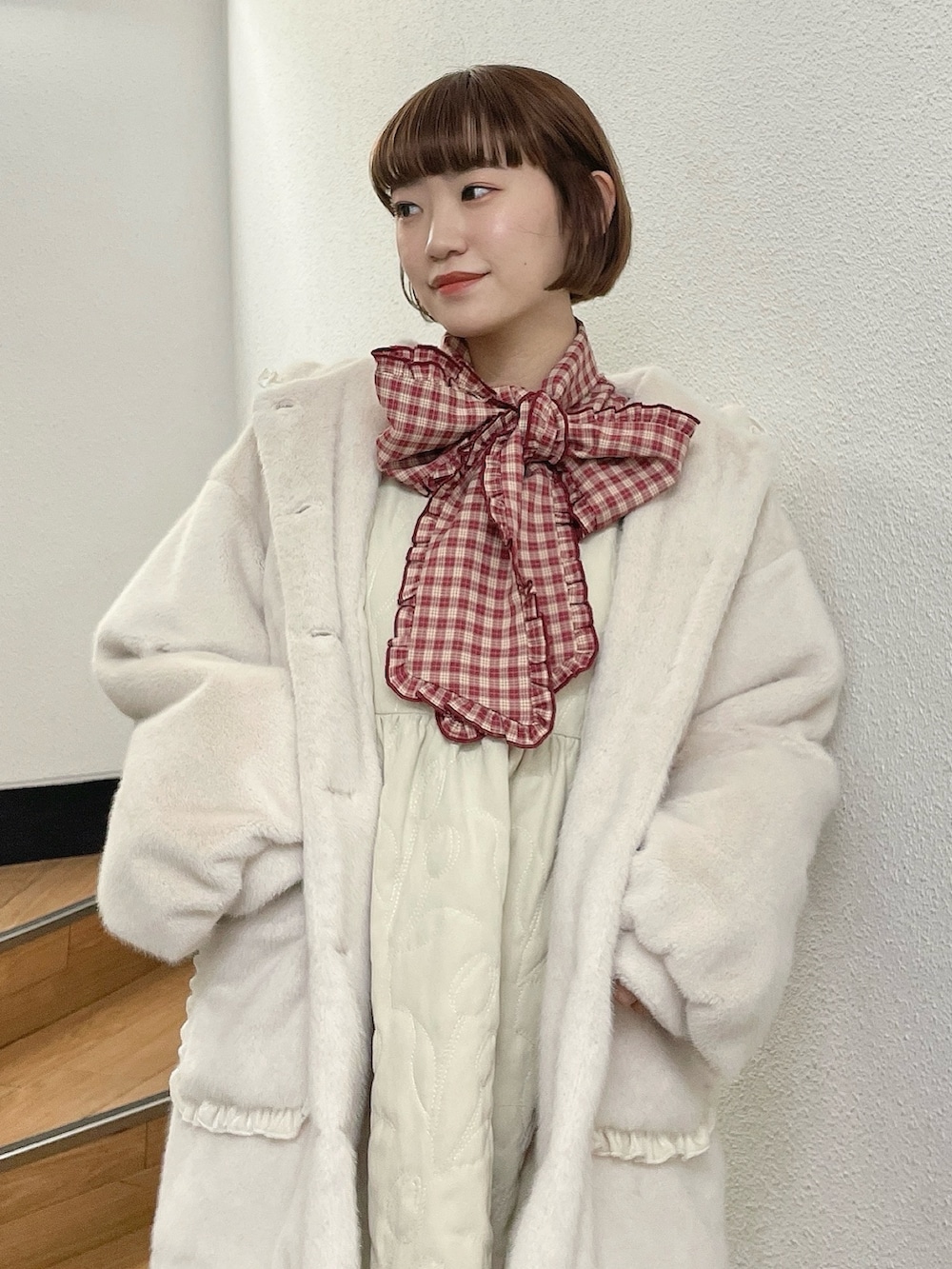 ホワイト系のダウンジャケット/コート、レッド系のシャツ/ブラウス、ホワイト系のワンピースを着用したレディースの冬コーディネートの4枚目の写真