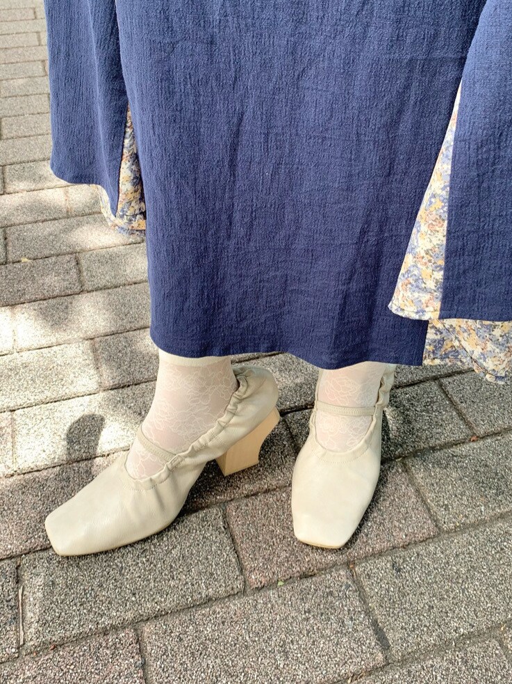 ホワイト系のパンプス、ベージュ系のシャツ/ブラウス、ブルー系のスカートを着用したレディースの春コーディネートの7枚目の写真