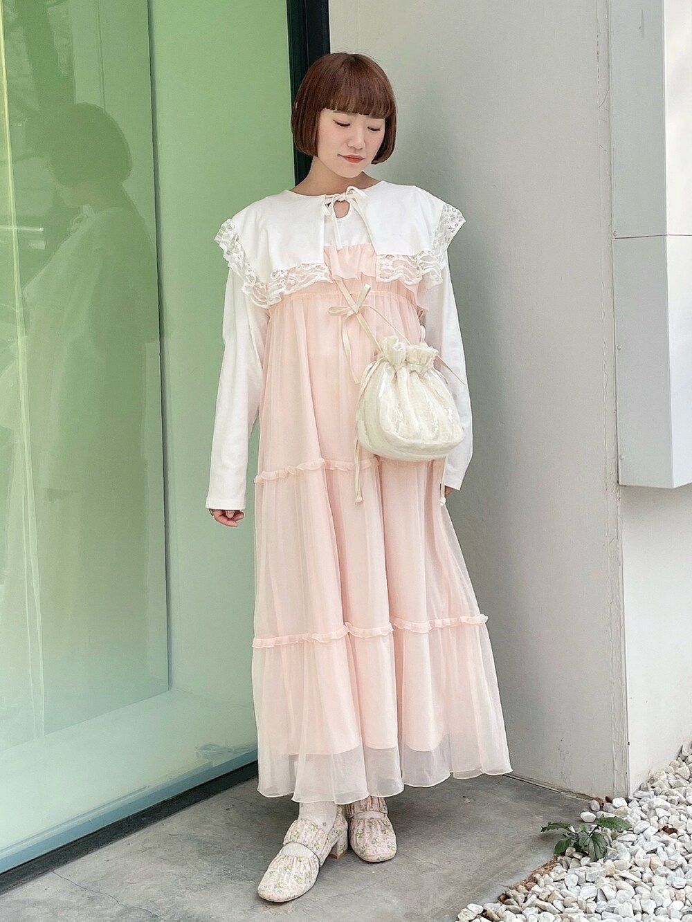 ホワイト系のTシャツ/カットソー、ホワイト系のショルダーバッグ、ピンク系のワンピースを着用したレディースの冬コーディネートの2枚目の写真