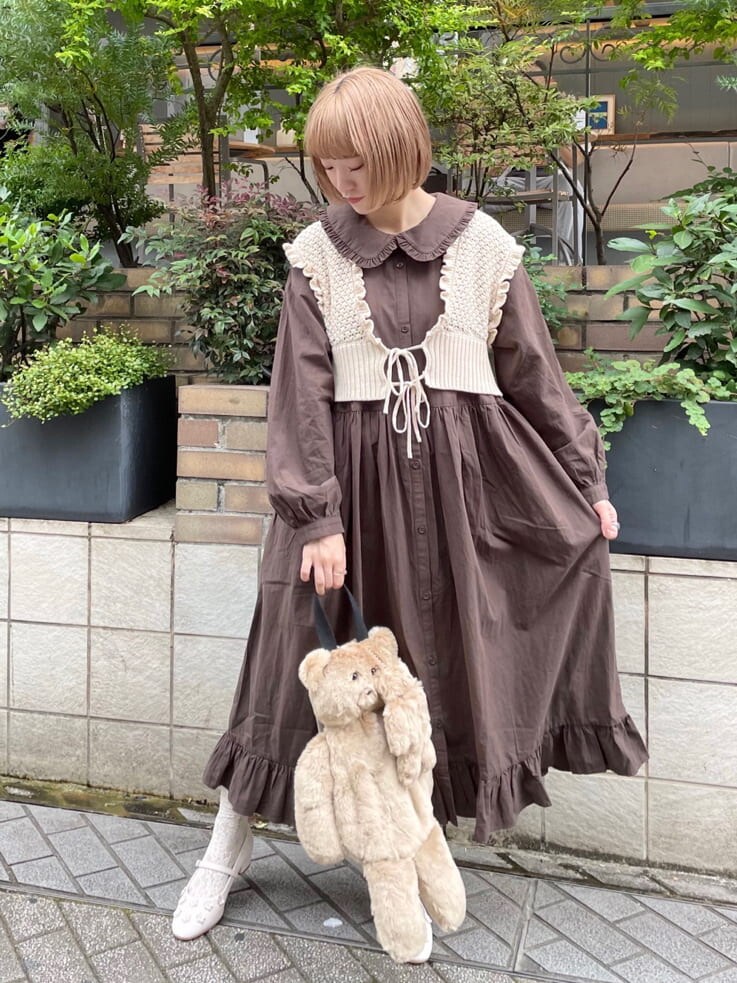 ベージュ系のハンドバッグ、ホワイト系のニット/セーター、ブラウン系のワンピースを着用したレディースの秋コーディネートの2枚目の写真