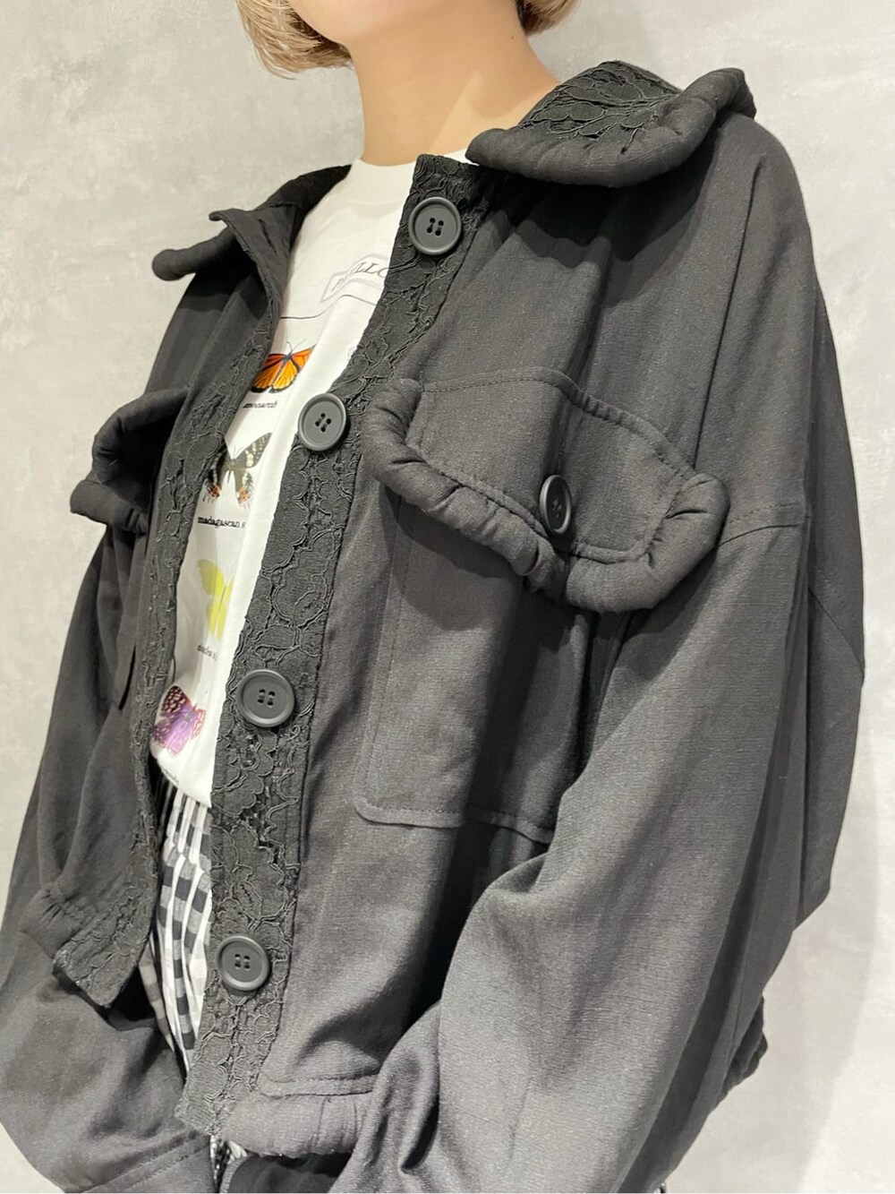 ブラック系のテーラードジャケット、ホワイト系のTシャツ/カットソー、ブラック系のスカートを着用したレディースの秋コーディネートの5枚目の写真