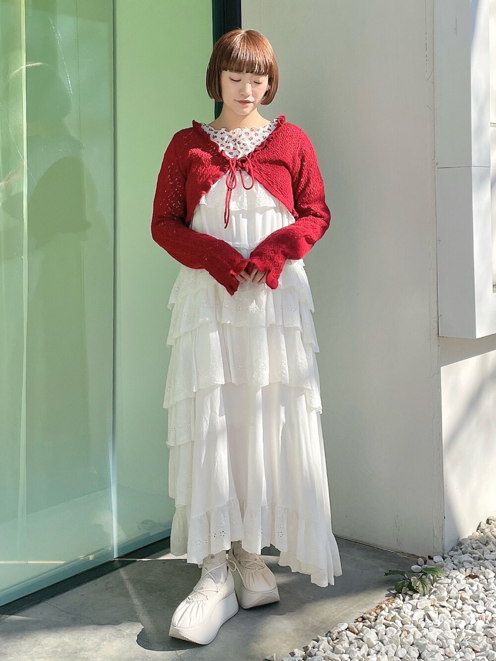 ピンク系のTシャツ/カットソー、レッド系のカーディガン/ボレロ、ホワイト系のワンピースを着用したレディースの冬コーディネートの2枚目の写真