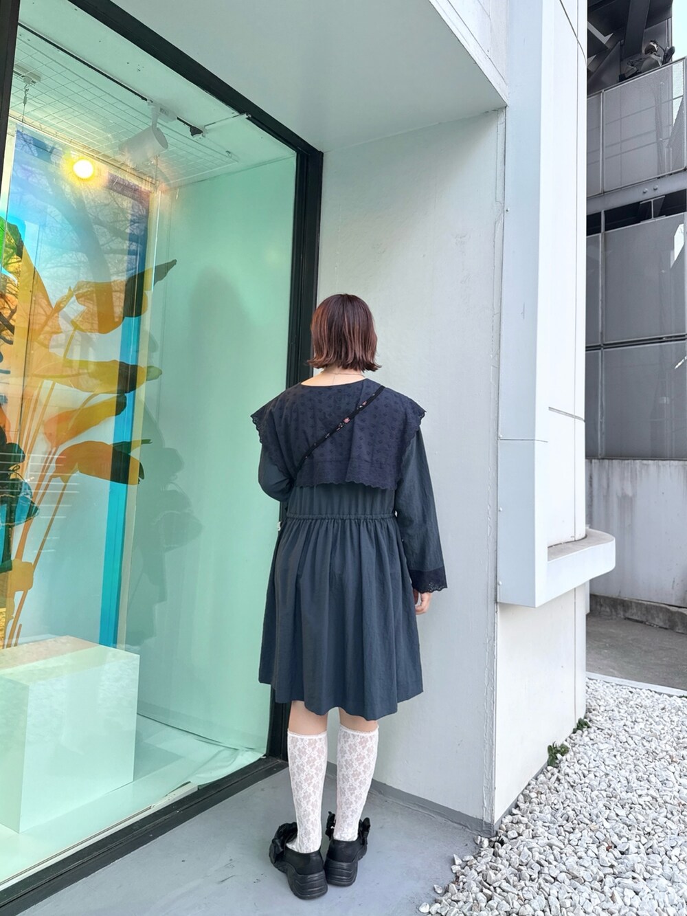 ブルー系のワンピース、ブラック系のショルダーバッグ、ブラック系のスニーカーを着用したレディースの冬コーディネートの3枚目の写真