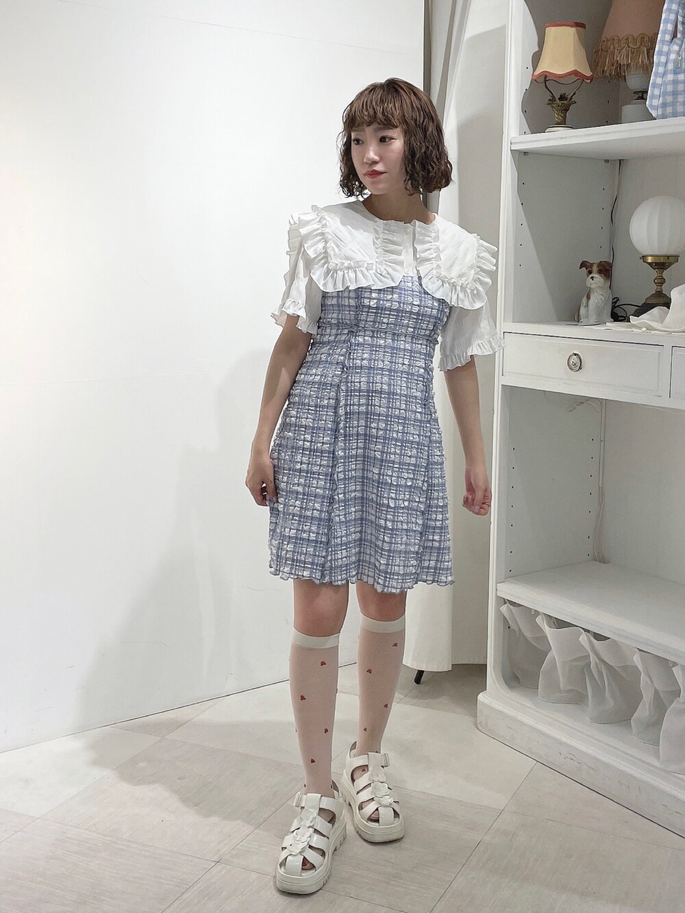 ホワイト系のシャツ/ブラウス、ブルー系のワンピース、ホワイト系のサンダルを着用したレディースの春コーディネートの2枚目の写真