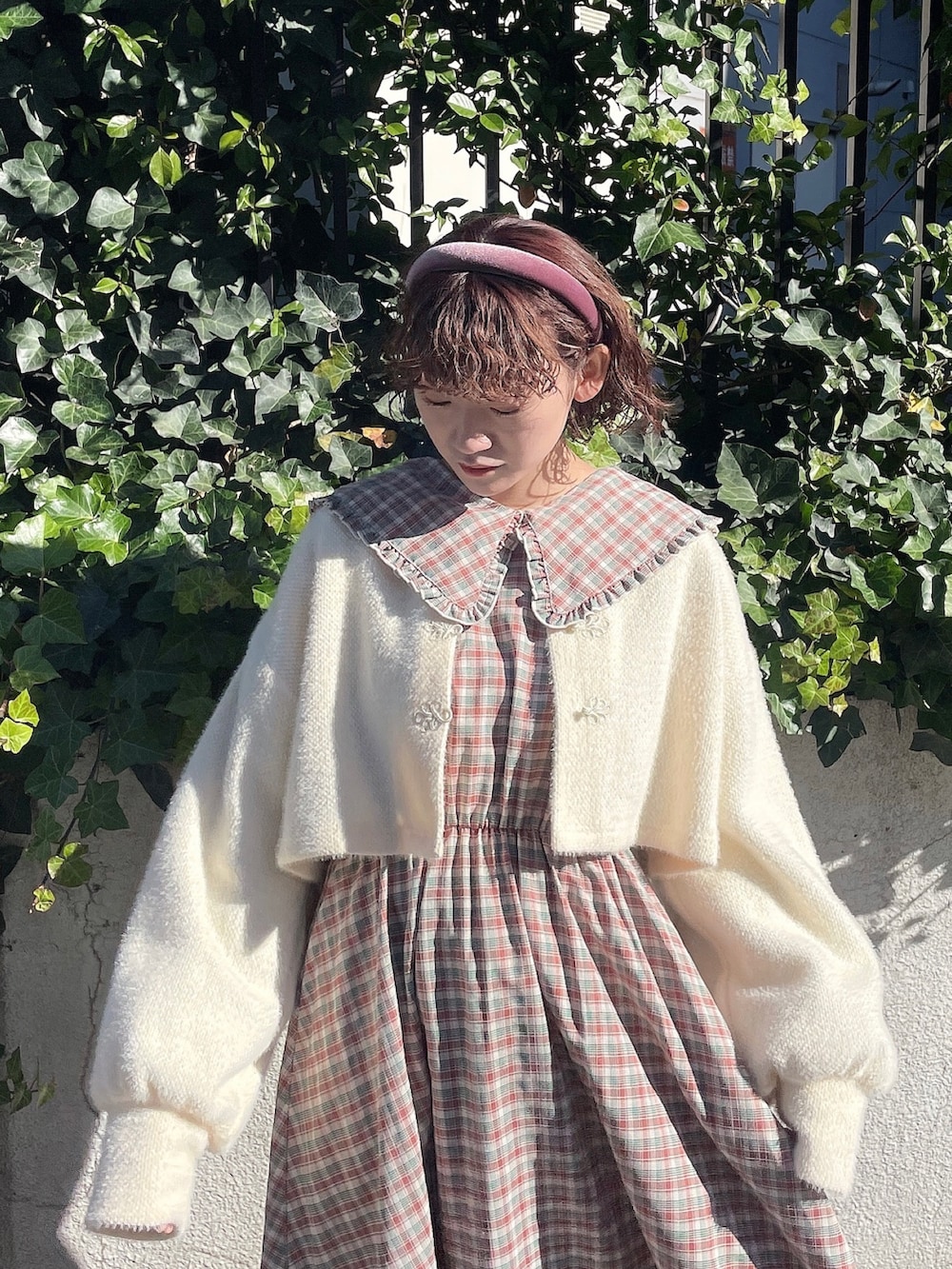 ホワイト系のカーディガン/ボレロ、ピンク系のワンピース、ホワイト系のローファーを着用したレディースの冬コーディネートの4枚目の写真