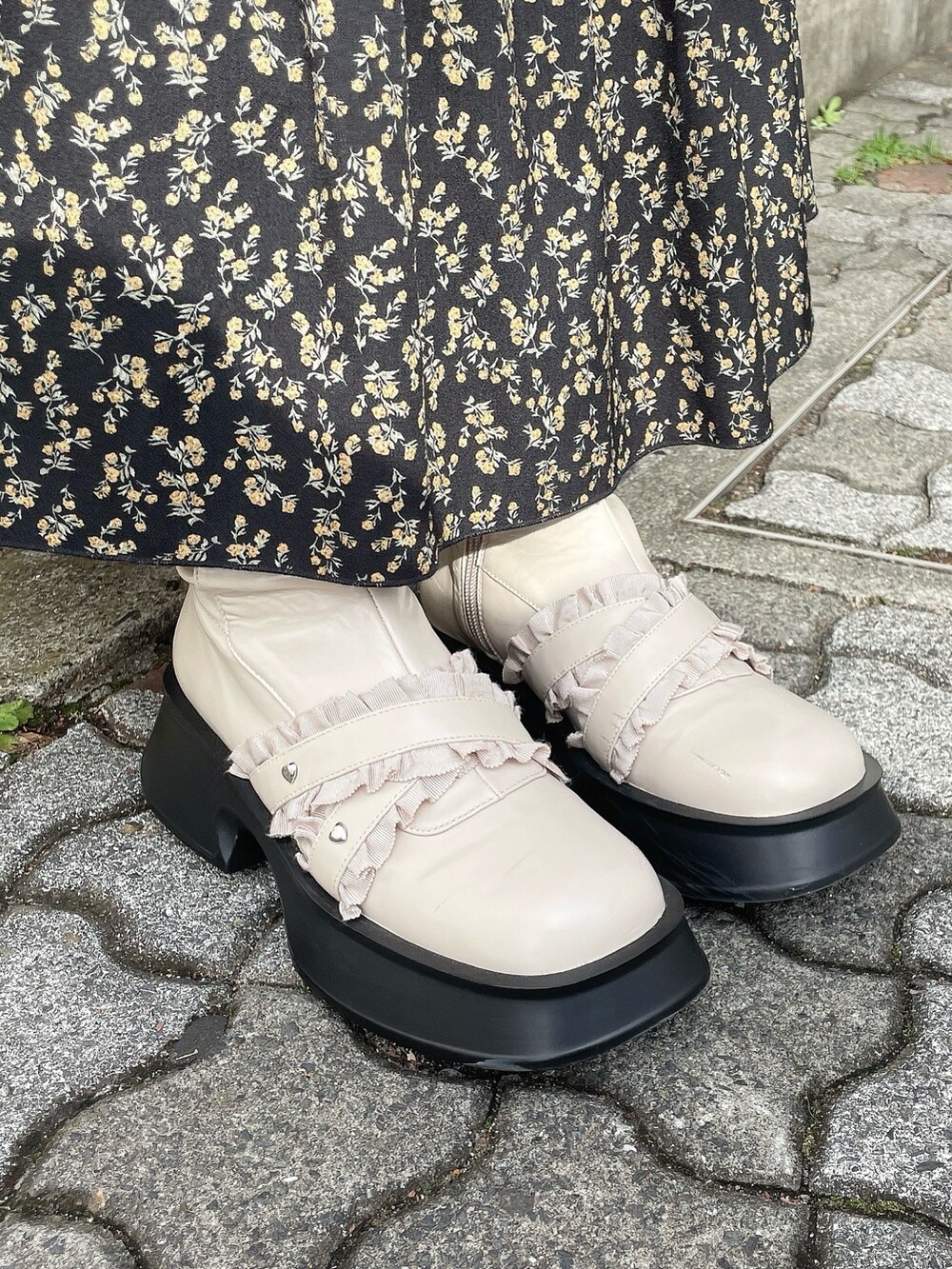 ピンク系のチェスターコート、ブラック系のスカート、グレー系のシャツ/ブラウスを着用したレディースの冬コーディネートの9枚目の写真