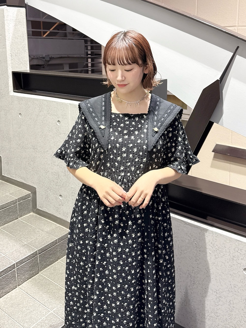 ブラック系のワンピース、ブラック系のスニーカー、ピンク系のネックレスを着用したレディースの春コーディネートの5枚目の写真