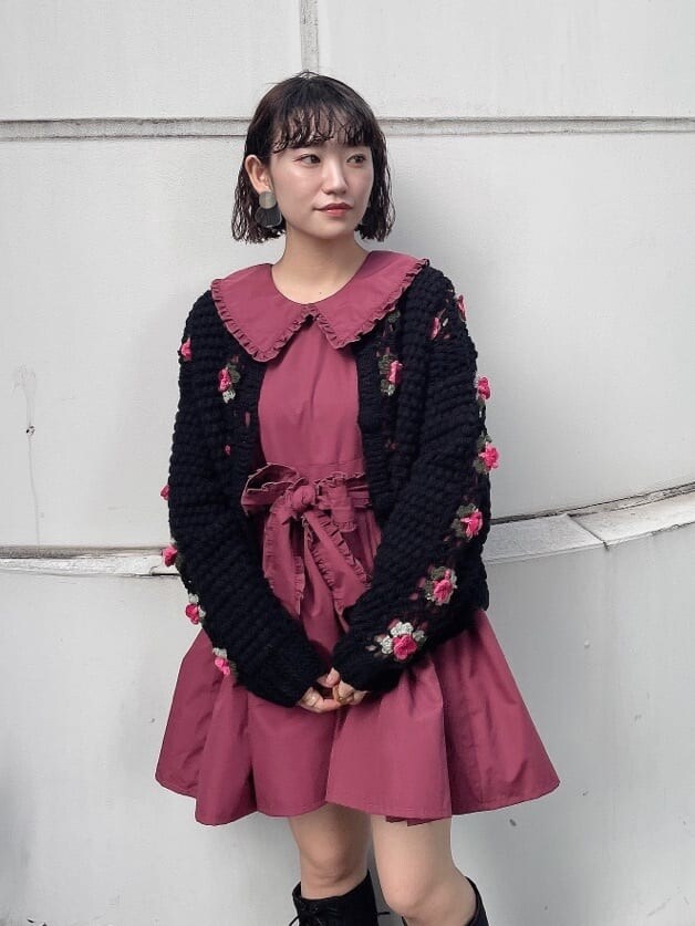 レッド系のワンピース、ブラック系のカーディガン/ボレロ、ブラック系のブーツを着用したレディースの秋コーディネートの4枚目の写真