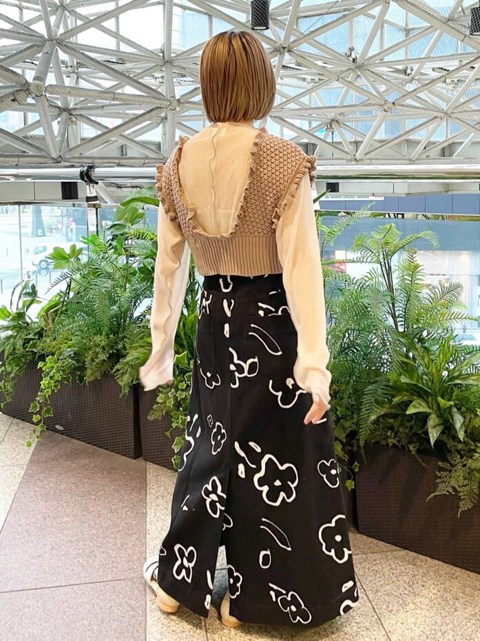 ベージュ系のニット/セーター、ホワイト系のチュニック、ブラック系のスカートを着用したレディースの夏コーディネートの3枚目の写真