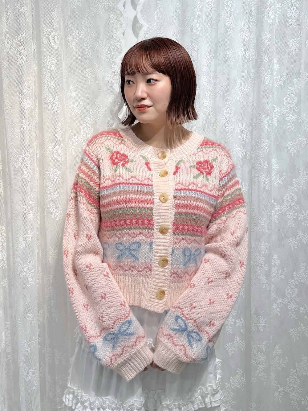 ピンク系のカーディガン/ボレロ、ホワイト系のスカート、ブラウン系のハンドバッグを着用したレディースの夏コーディネートの4枚目の写真