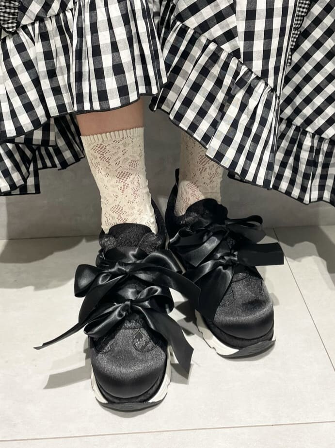 ブラック系のテーラードジャケット、ホワイト系のTシャツ/カットソー、ブラック系のスカートを着用したレディースの秋コーディネートの9枚目の写真