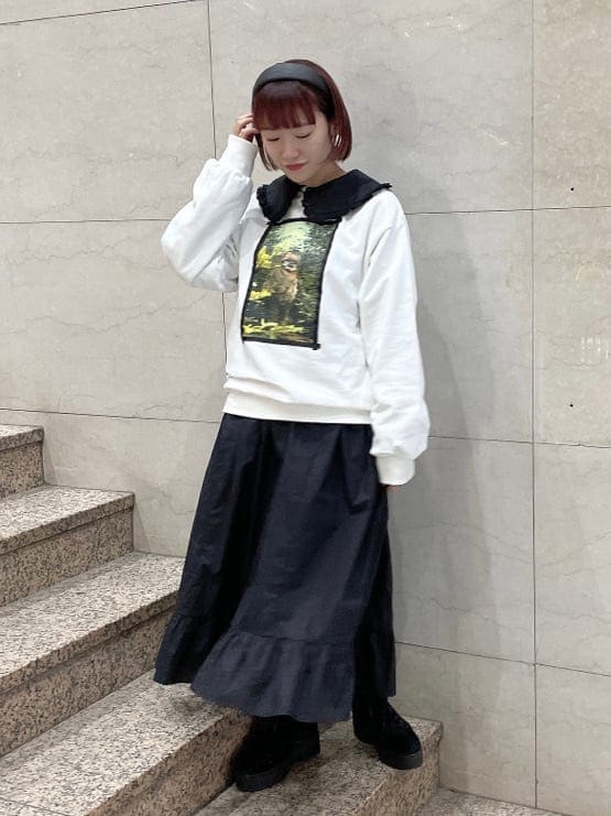 ブラック系のブーツ、ブラック系のワンピース、ホワイト系のTシャツ/カットソーを着用したレディースの冬コーディネートの2枚目の写真