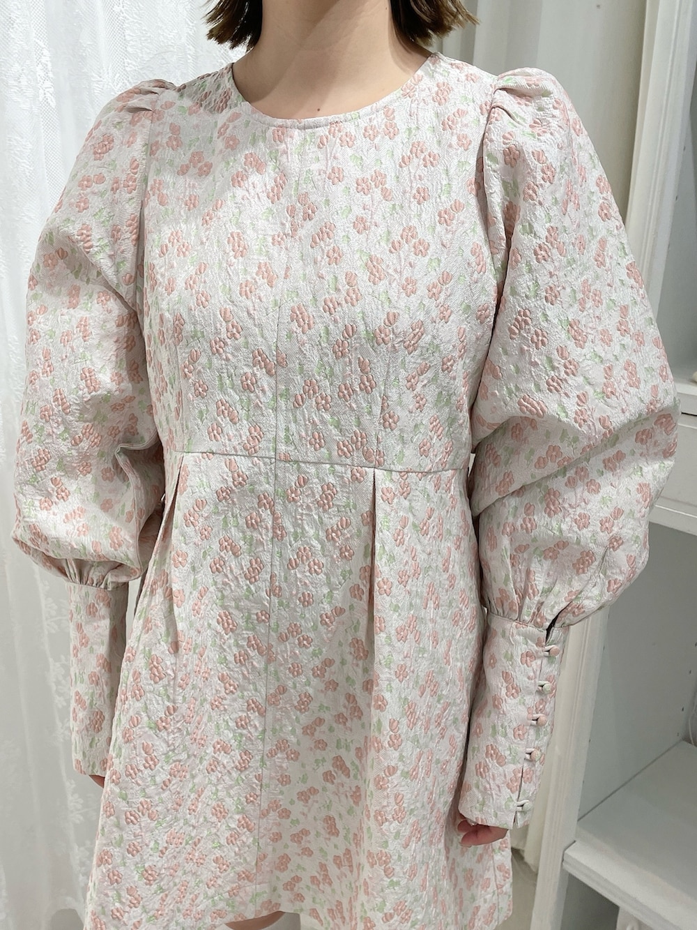 ピンク系のワンピース、ベージュ系のサンダルを着用したレディースの冬コーディネートの6枚目の写真