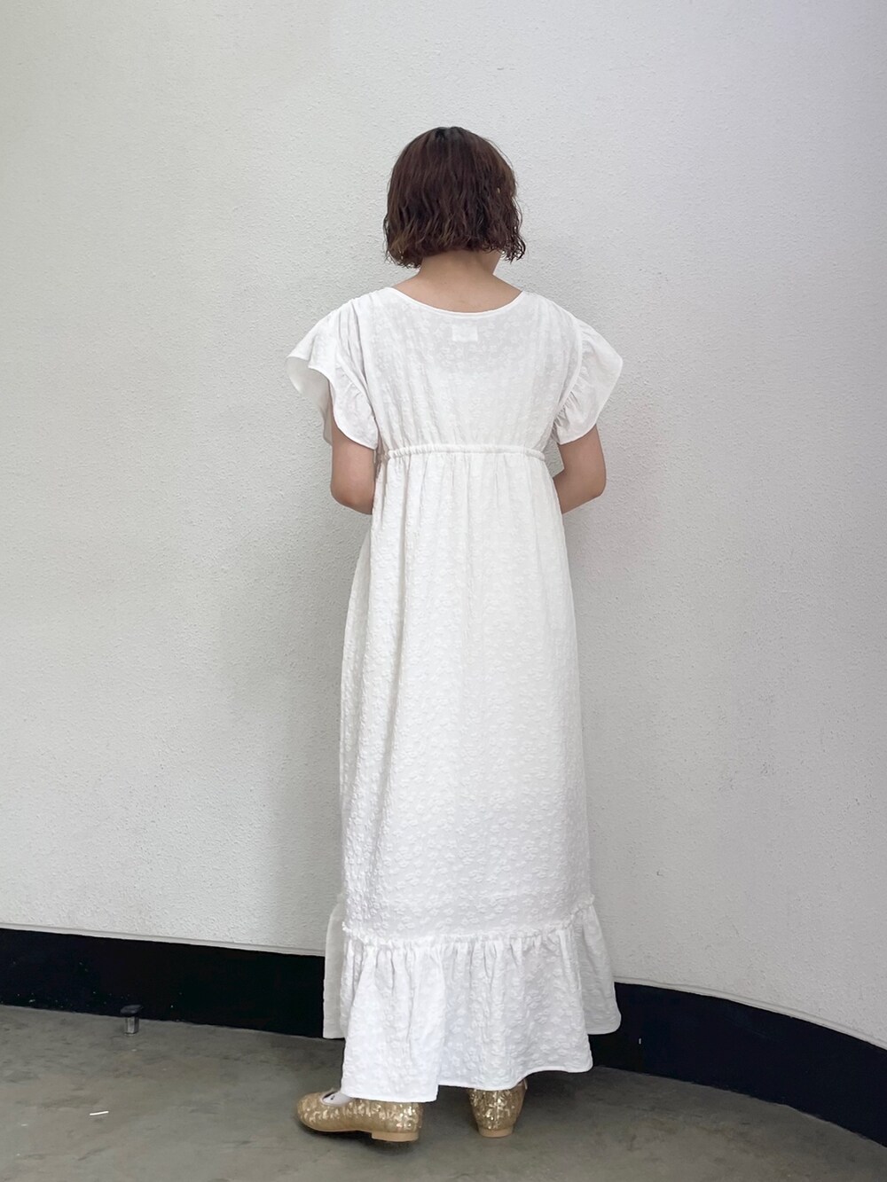 ホワイト系のキャミソール、ホワイト系のワンピース、ゴールド系のパンプスを着用したレディースの春コーディネートの3枚目の写真