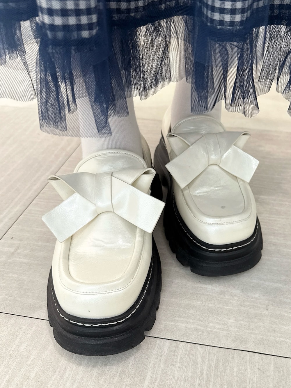 ホワイト系のニット/セーター、ブルー系のワンピース、ホワイト系のローファーを着用したレディースの冬コーディネートの5枚目の写真