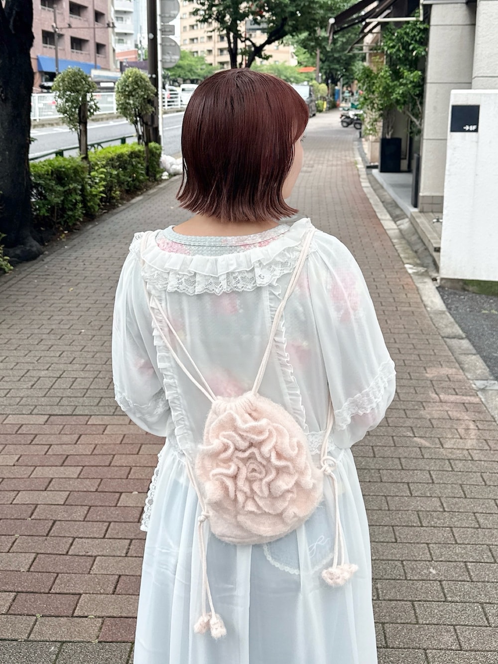 グリーン系のTシャツ/カットソー、ホワイト系のワンピース、ブルー系のデニムパンツを着用したレディースの夏コーディネートの6枚目の写真