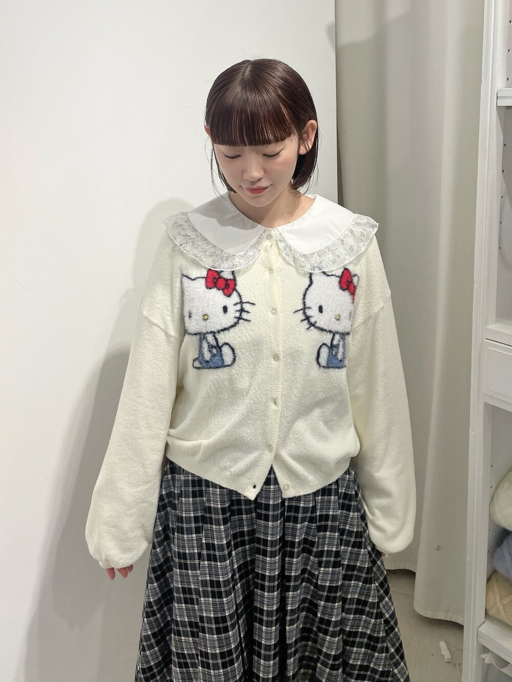 ホワイト系のカーディガン/ボレロ、シルバー系のシャツ/ブラウス、ブラック系のスカートを着用したレディースの秋コーディネートの5枚目の写真