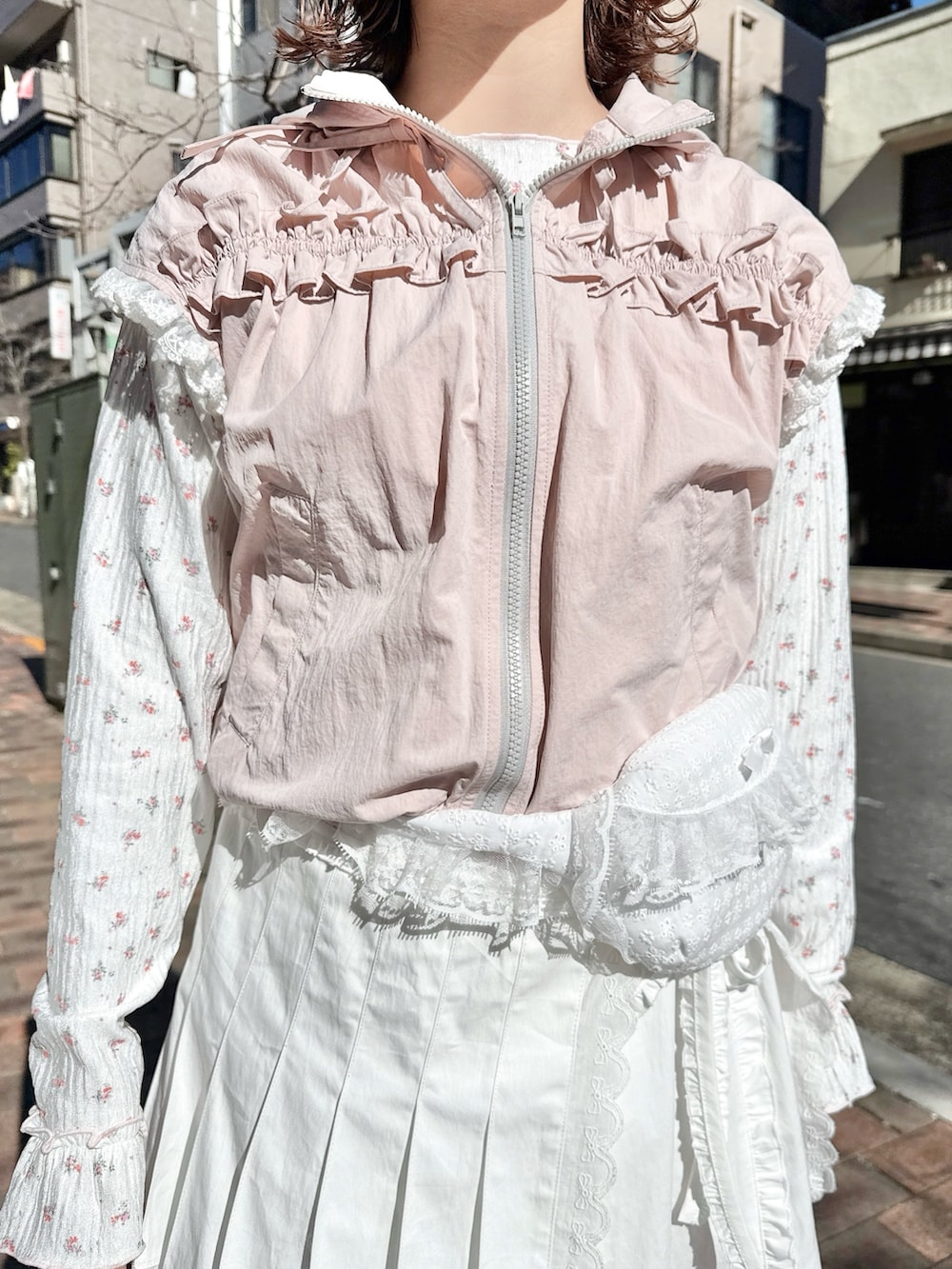 ピンク系のベスト、ピンク系のTシャツ/カットソー、ホワイト系のスカートを着用したレディースの春コーディネートの5枚目の写真