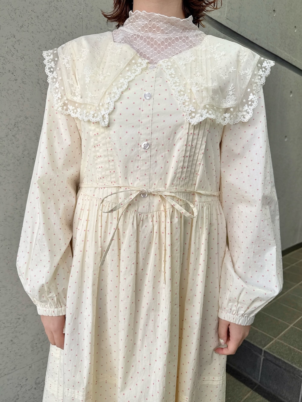 ベージュ系のワンピース、ピンク系のTシャツ/カットソー、ホワイト系のショルダーバッグを着用したレディースの春コーディネートの7枚目の写真