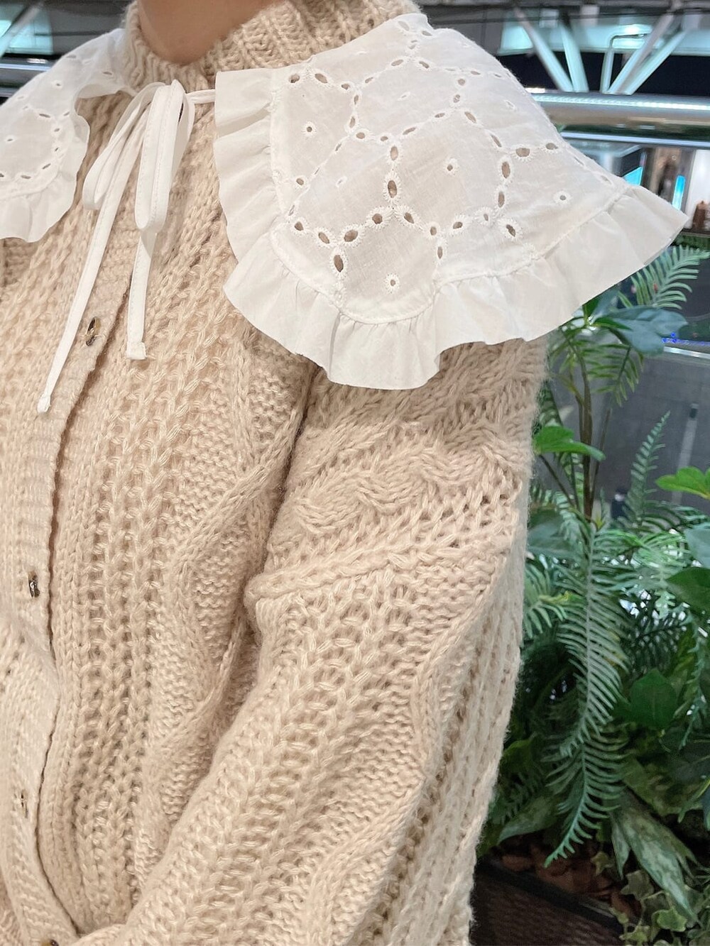 ベージュ系のスカート、ホワイト系のローファー、グリーン系のショルダーバッグを着用したレディースの冬コーディネートの5枚目の写真