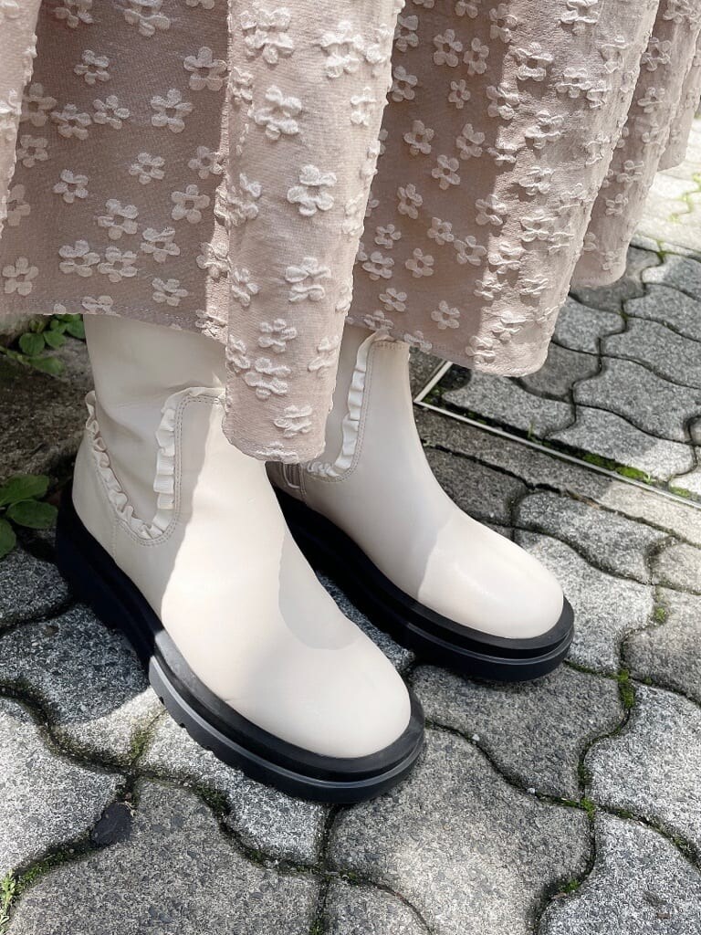 ホワイト系のカーディガン/ボレロ、ホワイト系のブーツ、ピンク系のニット/セーターを着用したレディースの夏コーディネートの4枚目の写真