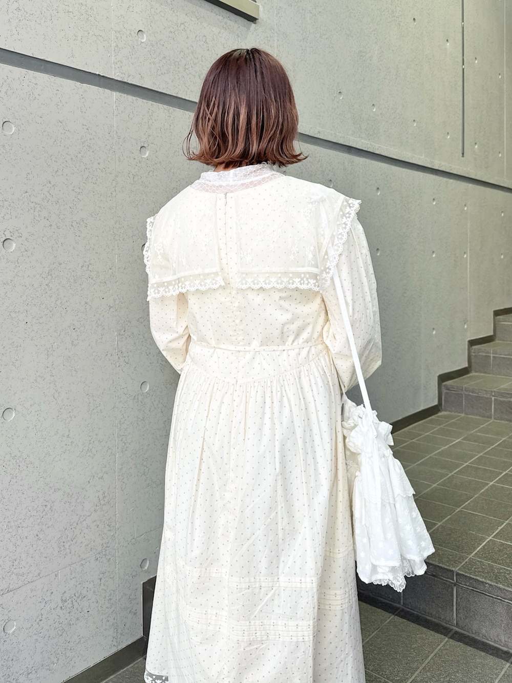 ベージュ系のワンピース、ピンク系のTシャツ/カットソー、ホワイト系のショルダーバッグを着用したレディースの春コーディネートの5枚目の写真