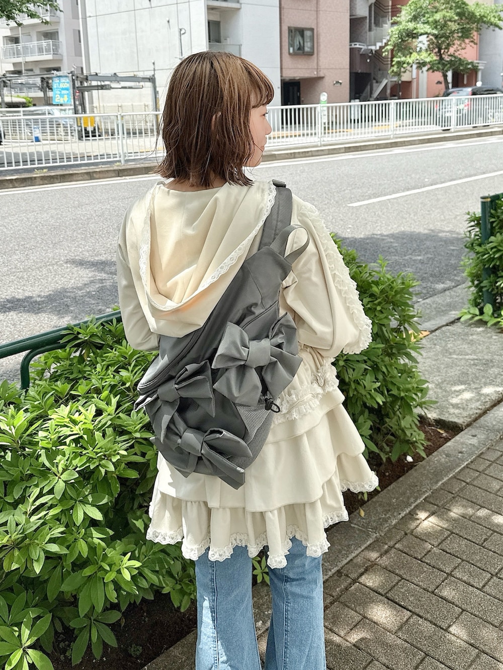 ブルー系のデニムパンツ、ホワイト系のスカート、ホワイト系のパーカーを着用したレディースの春コーディネートの5枚目の写真