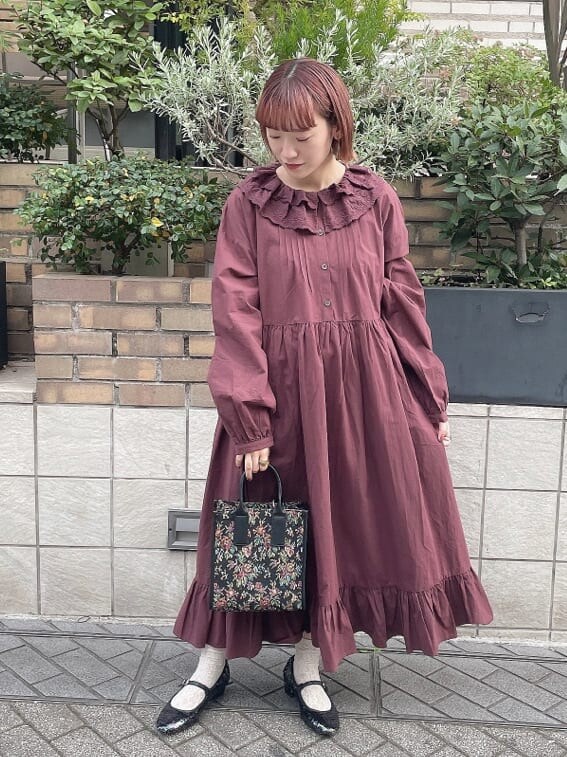 ブルー系のチェスターコート、レッド系のワンピース、その他のパンプスを着用したレディースの秋コーディネートの5枚目の写真