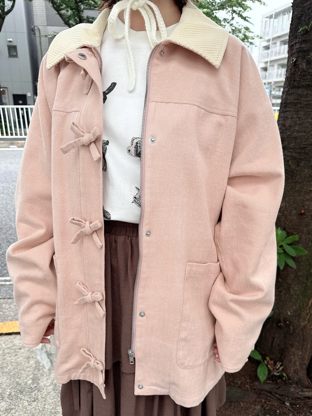 ピンク系のブルゾン、ホワイト系のTシャツ/カットソー、ブラウン系のスカートを着用したレディースの夏コーディネートの7枚目の写真