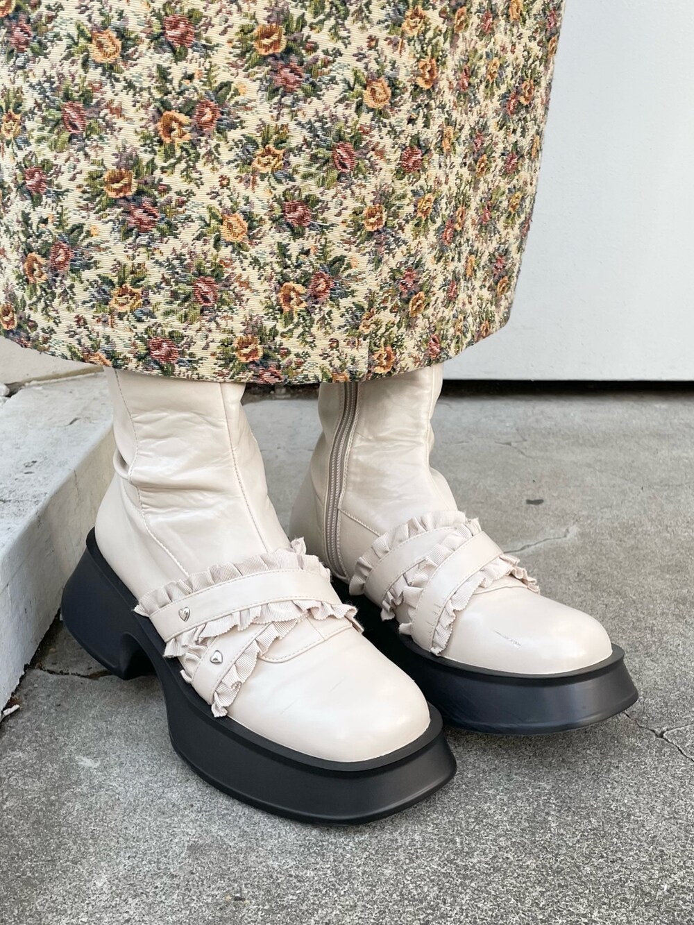 ホワイト系のシャツ/ブラウス、ベージュ系のジャンパースカート、ホワイト系のブーツを着用したレディースの秋コーディネートの6枚目の写真