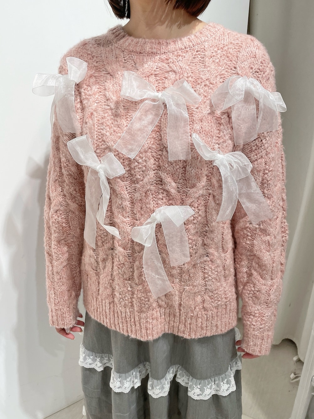 グレー系のスカート、ピンク系のニット/セーター、ホワイト系のローファーを着用したレディースの秋コーディネートの6枚目の写真