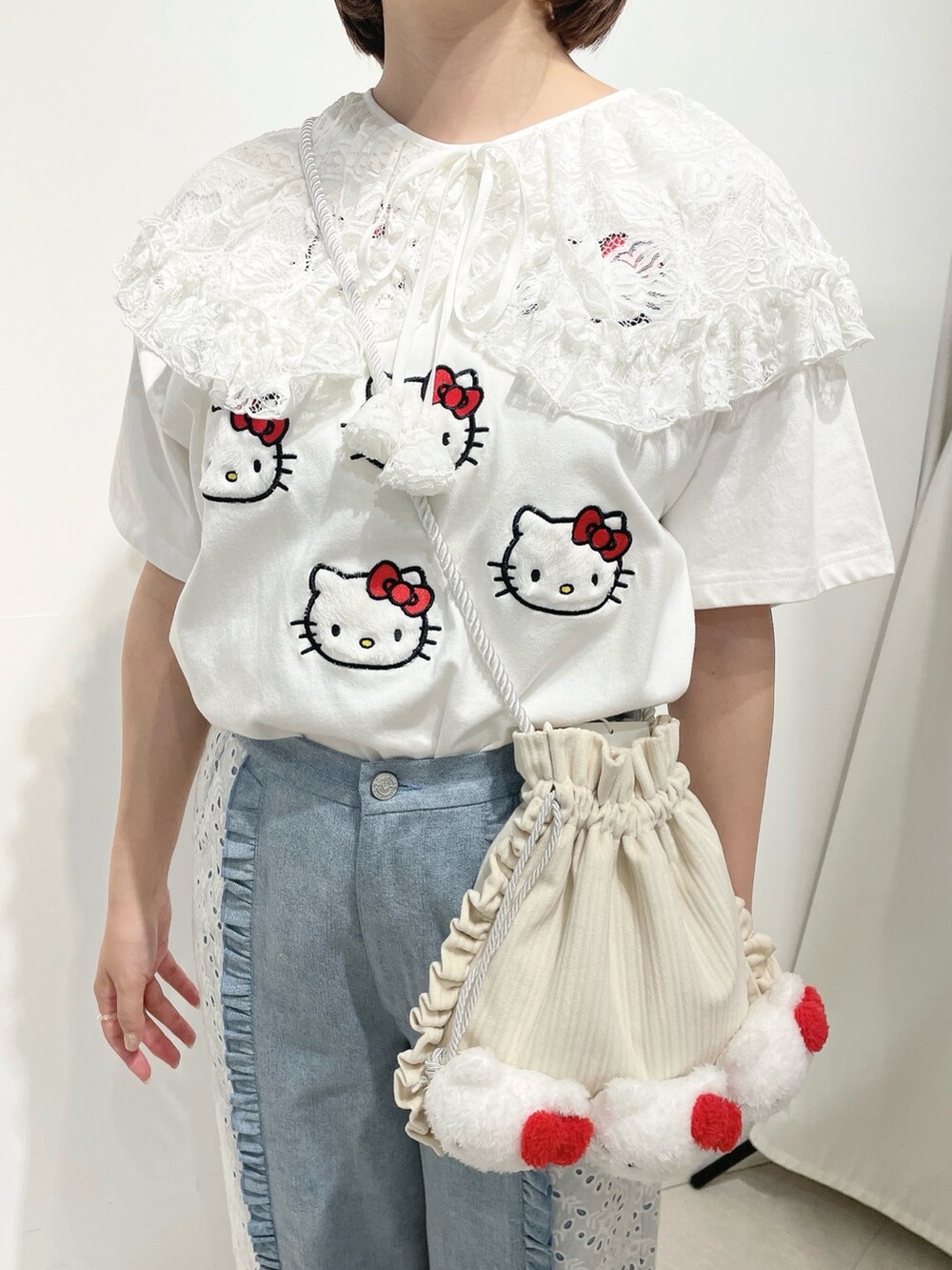 ブルー系のデニムパンツ、ホワイト系のスニーカー、ホワイト系のショルダーバッグを着用したレディースの春コーディネートの6枚目の写真