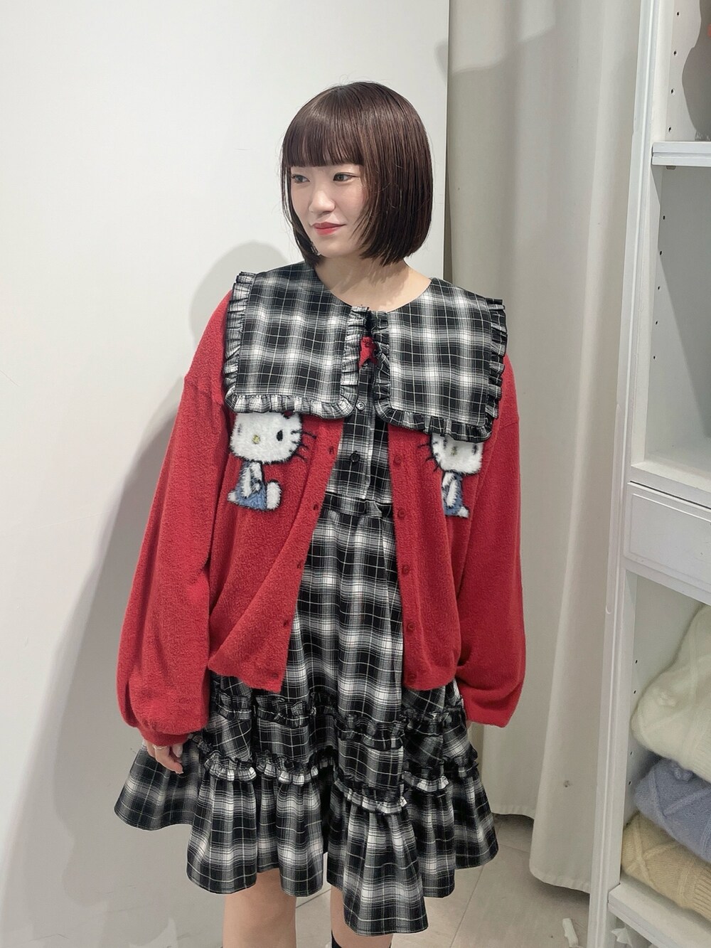 ブラック系のワンピース、レッド系のカーディガン/ボレロ、ブラック系のローファーを着用したレディースの秋コーディネートの4枚目の写真