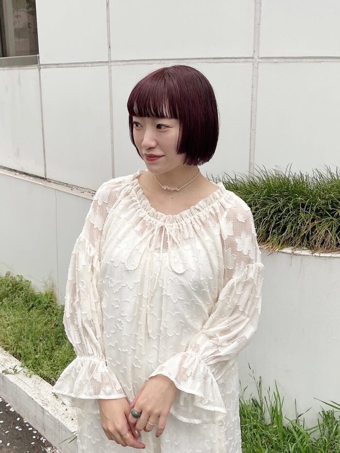 ホワイト系のワンピース、ベージュ系のパンプス、ベージュ系のチョーカーを着用したレディースの春コーディネートの3枚目の写真